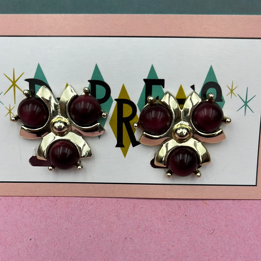 Gold clip-on earring with dark Red stones